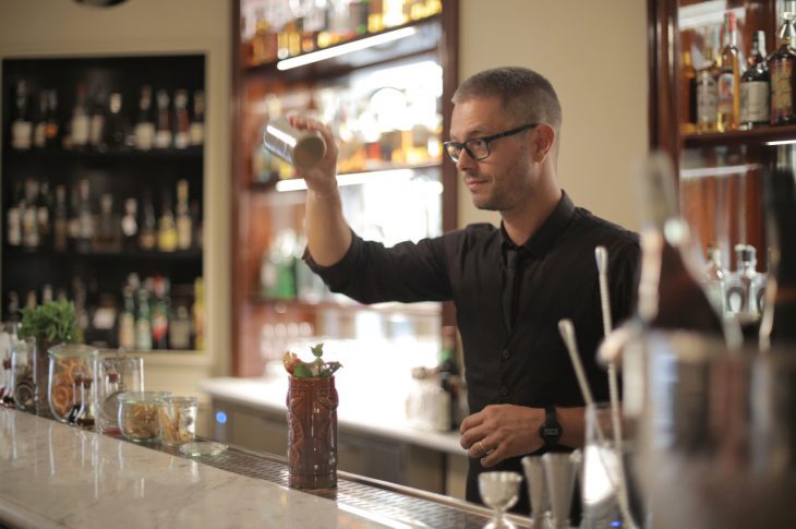 Mand laver drinks til familie som bartender